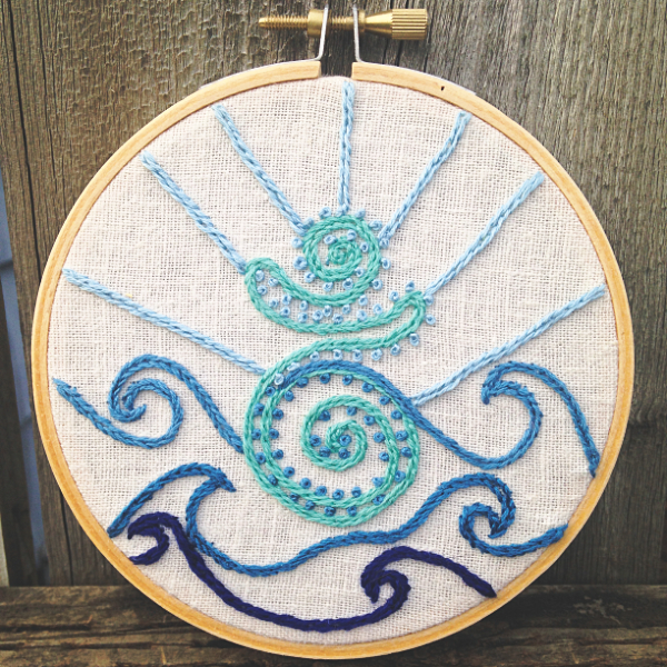 embroidery hoop featuring an aqua goddess with waves and sky in shades of blue