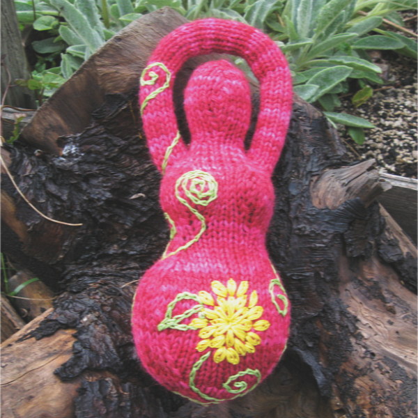 deep pink knitted goddess with yellow and green embroidery
