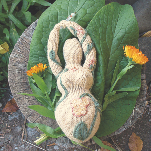 beige goddess with embroidery and beading on a background of leaves and flowers