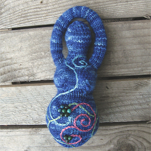 variegated blue knitted goddess with pink and blue embroidered spirals and beaded flowers