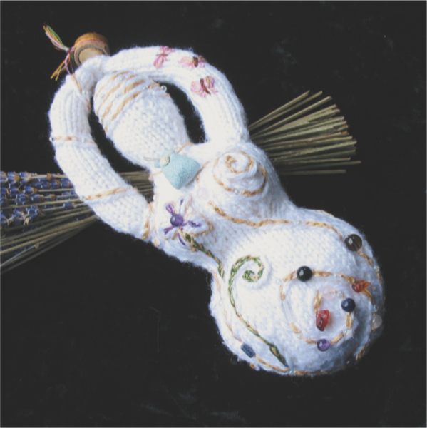 a white knitted goddess adorned with embroidery and beads