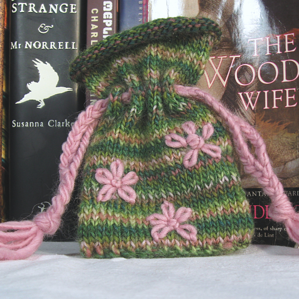 green and pink variegated knitted pouch embroidered with pink flowers