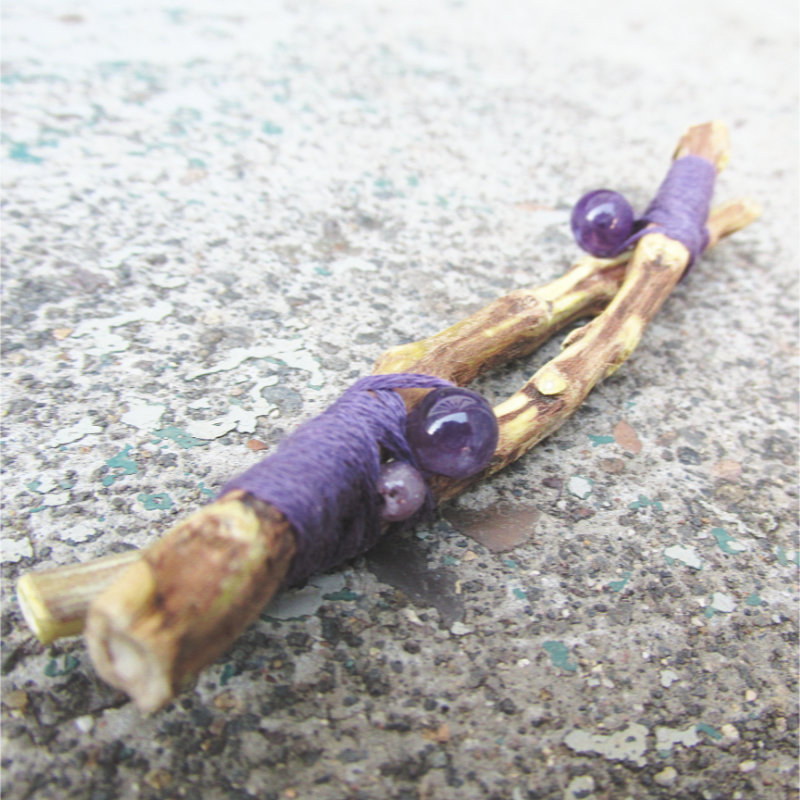 sage stems woven together with purple thread, adorned with amethyst beads