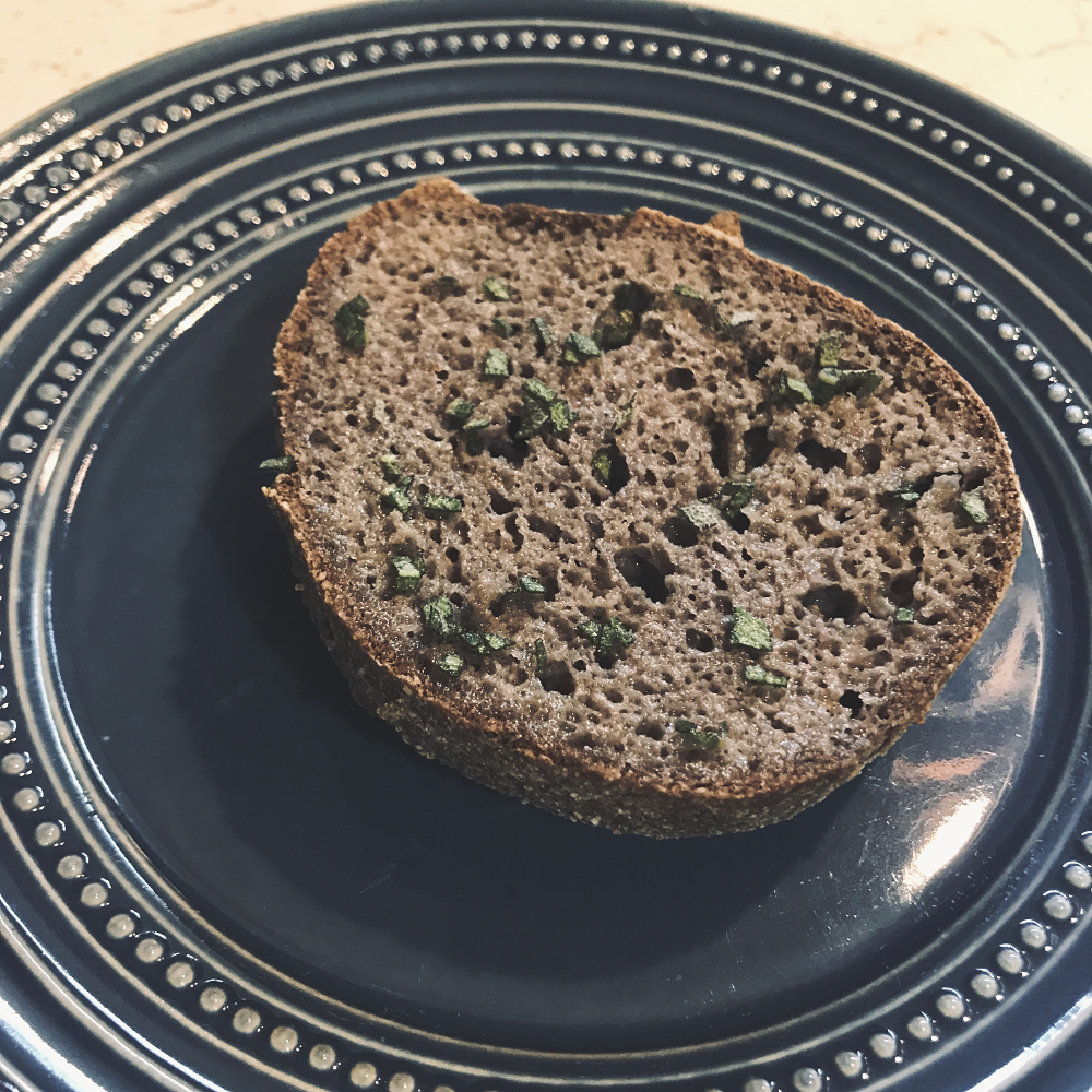 a roll with butter and sage on a blue plate