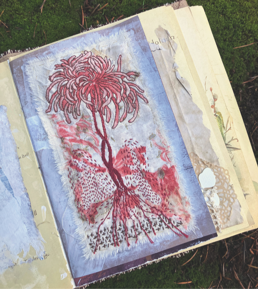 cloth printed with an orange spider mum, with hand stitched outline and stems