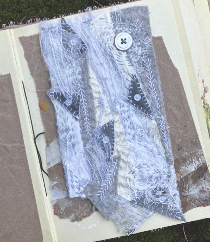 a fabric collage in shades of white and gray with hand stitching, beads, sequins, and buttons