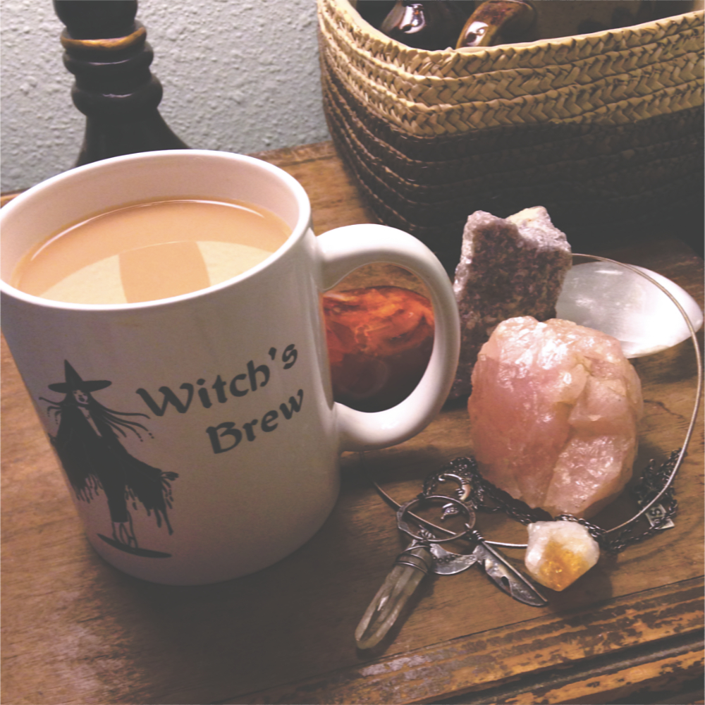crystals, a necklace, and a mug with a drawing of a witch and the words "Witch's brew"