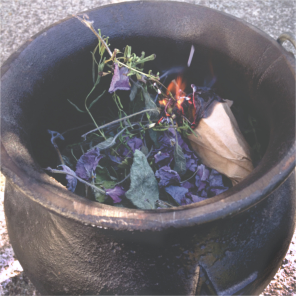 a small cauldron with burning herbs inside