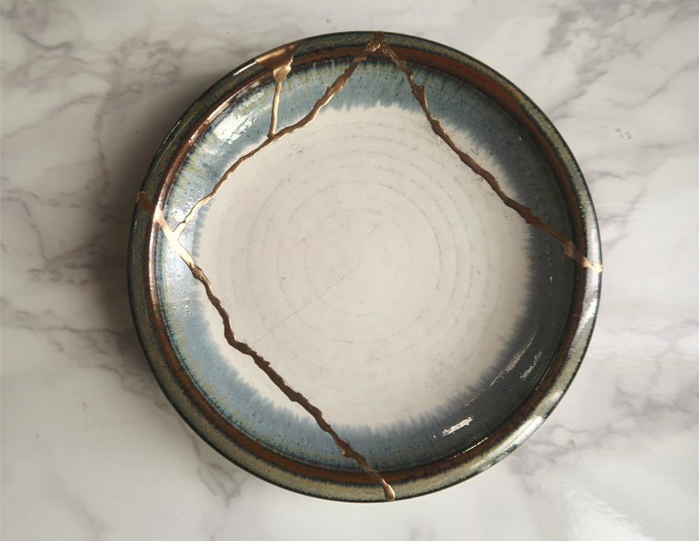a blue, whiite and brown plate mended with gold