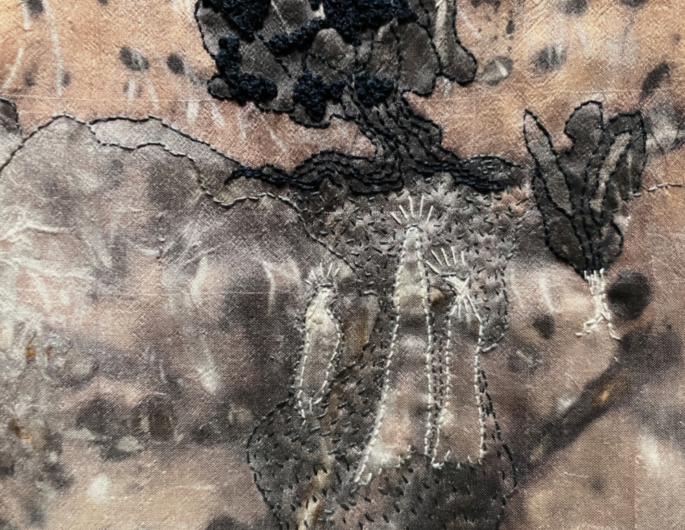 a surreal piece of stitching in shades of gray, gold, black, and white featuring three indistinct figures walking through hills toward a huge tree